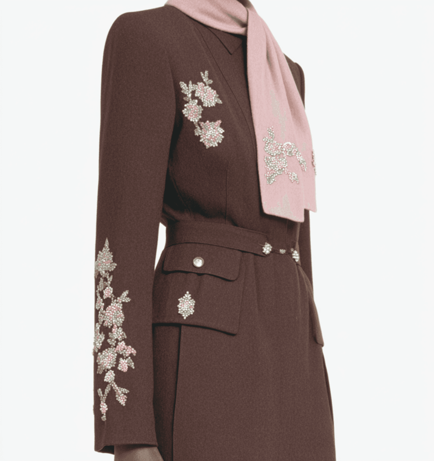 Close detail of a chocolate brown dress embroidered with crystal flowers, worn with a pink scarf