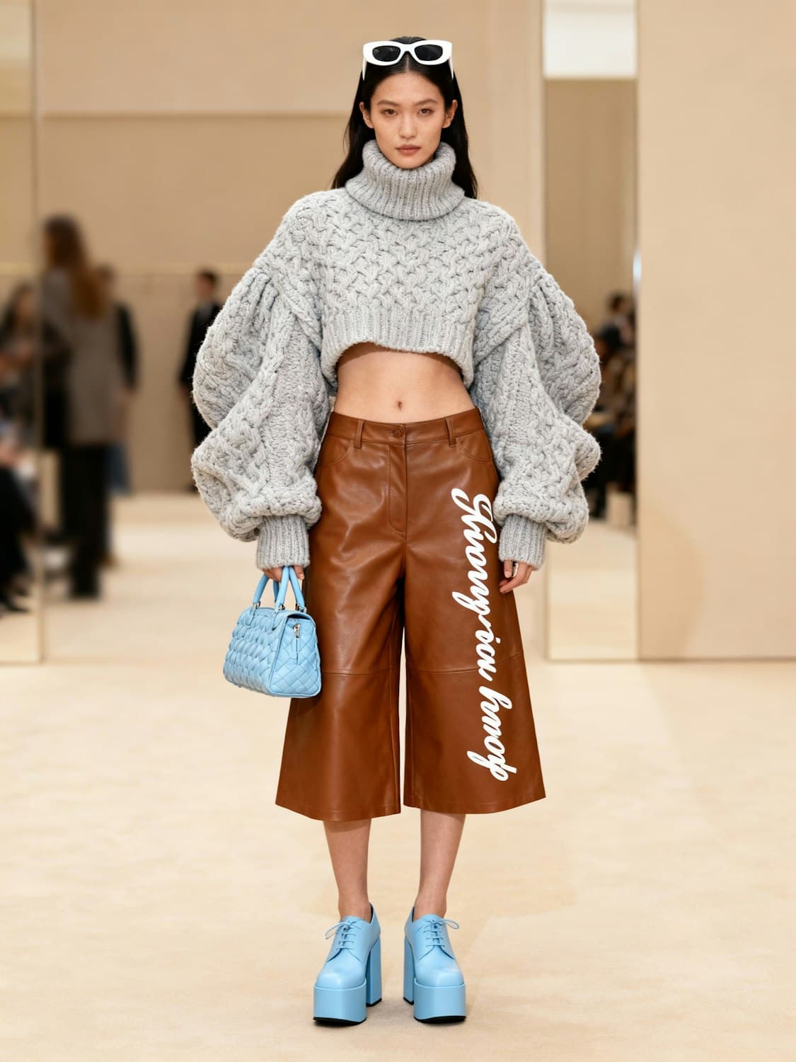 Cropped grey cable knit sweater, brown leather culottes and sky blue platform shoes with a quilted bag